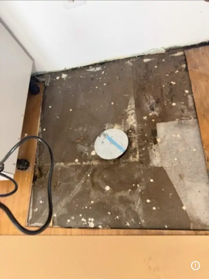 Chão da cozinha levantado com esgoto à vista, antes da obra